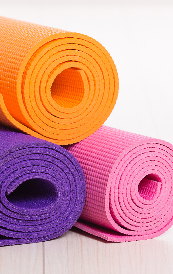 Orange, purple and pink rolled yoga mats